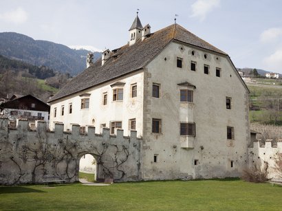L‘Epifania Vecchio castello con muro di cinta e cancello in paesaggio montano