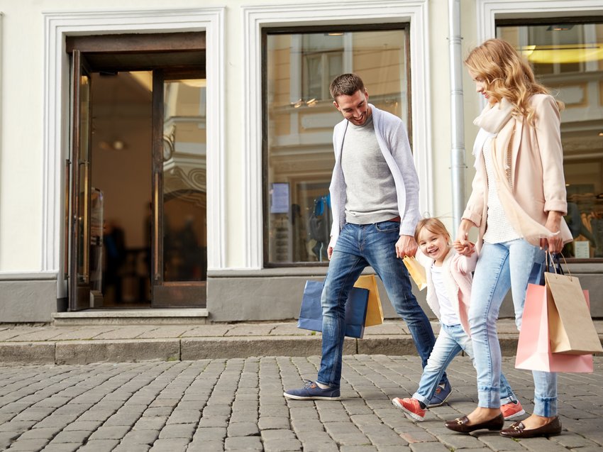 Geheimtipp Hotels in Südtirol 😎☀️ Familie mit Einkaufstaschen geht lachend auf gepflastertem Gehweg