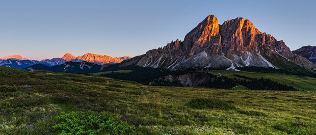 Geheimtipp Hotels in Südtirol 😎☀️ Sonnenuntergang über grünen Wiesen und markanten Bergen der Dolomiten