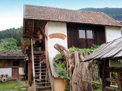 Il Museo della Frutticoltura a Lana Vecchia casa in legno con cartello museo e giardino in zona rurale