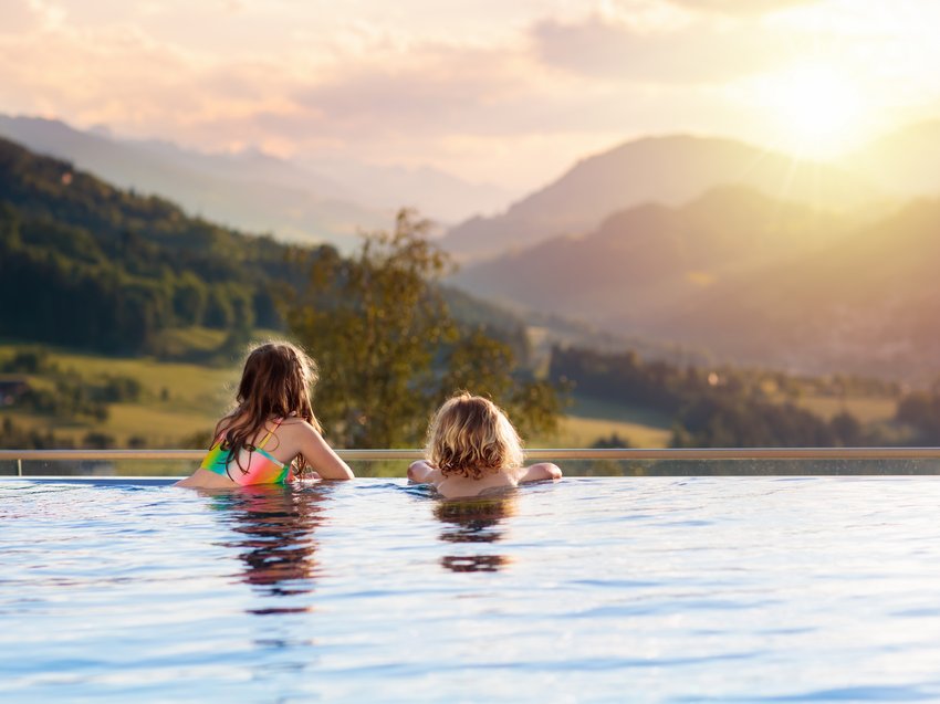 Geheimtipp Hotels in Südtirol 😎☀️ Zwei Kinder im Pool mit Blick auf Sonnenuntergang und Berge