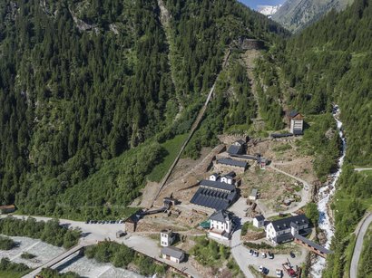L‘Epifania Veduta aerea di un insediamento montano con edifici, bosco e fiume nelle Alpi