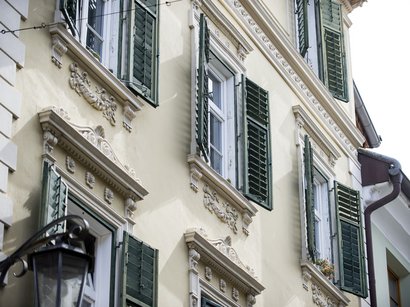 L‘Epifania Facciata di casa gialla con persiane verdi in stile storico