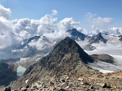 L‘Epifania Cima di montagna con rifugio e ghiacciaio sotto un cielo nuvoloso