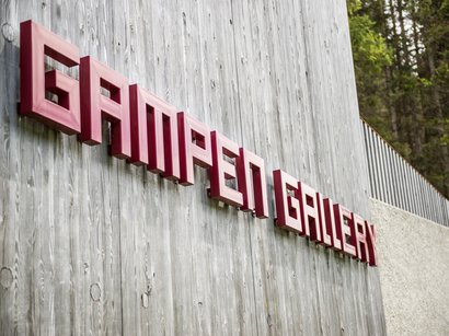 L‘Epifania Insegna rossa con scritto Gamper Gallery su una parete di legno