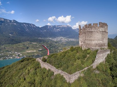 L‘Epifania Rovina di castello su collina verde con vallata e montagne sullo sfondo
