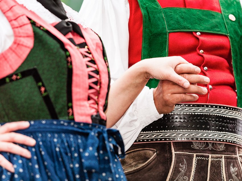 Geheimtipp Hotels in Südtirol 😎☀️ Paar in traditioneller bayerischer Tracht hält Händchen
