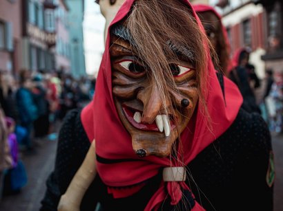 Transumanza in Alto Adige: un’importante tradizione Maschera di strega di legno con fazzoletto rosso a una sfilata di strada