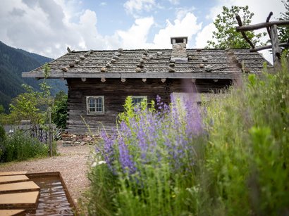Il Museo della Frutticoltura a Lana Vecchia casa in legno con tetto di pietra e fiori di lavanda sulle Alpi