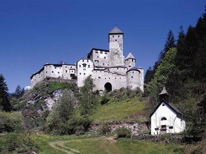 L‘Epifania Castello medievale su collina verde con cielo azzurro