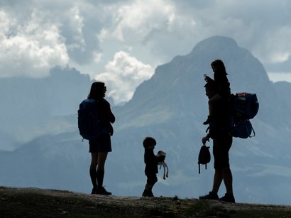 L‘Epifania Sagome di una famiglia in escursione con montagne e nuvole sullo sfondo