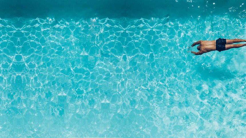 Geheimtipp Hotels in Südtirol 😎☀️ Mann taucht vorne im klaren blauen Wasser