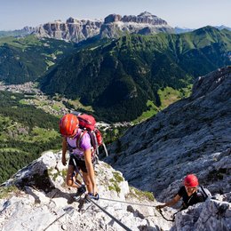 Escursioni in Alto Adige: esperienze indimenticabili! Due scalatori con caschi arrampicano una parete rocciosa sulle Alpi