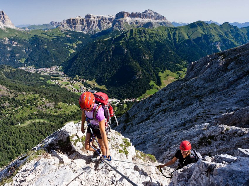Geheimtipp Hotels in Südtirol 😎☀️ Zwei Kletterer mit Helmen erklimmen eine Bergwand in den Alpen